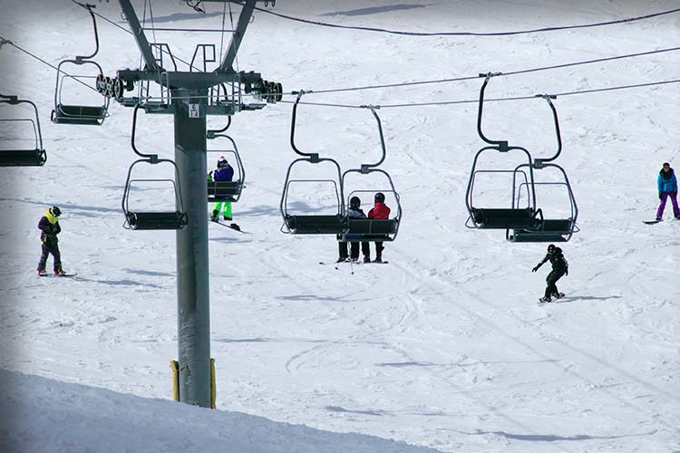 スキー場でスキーを楽しむ人々やリストに乗っている人たち