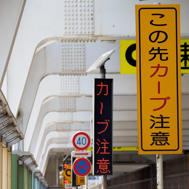 高速道路でよく見る日本語のみのタテ型注意看板「この先カーブ注意」